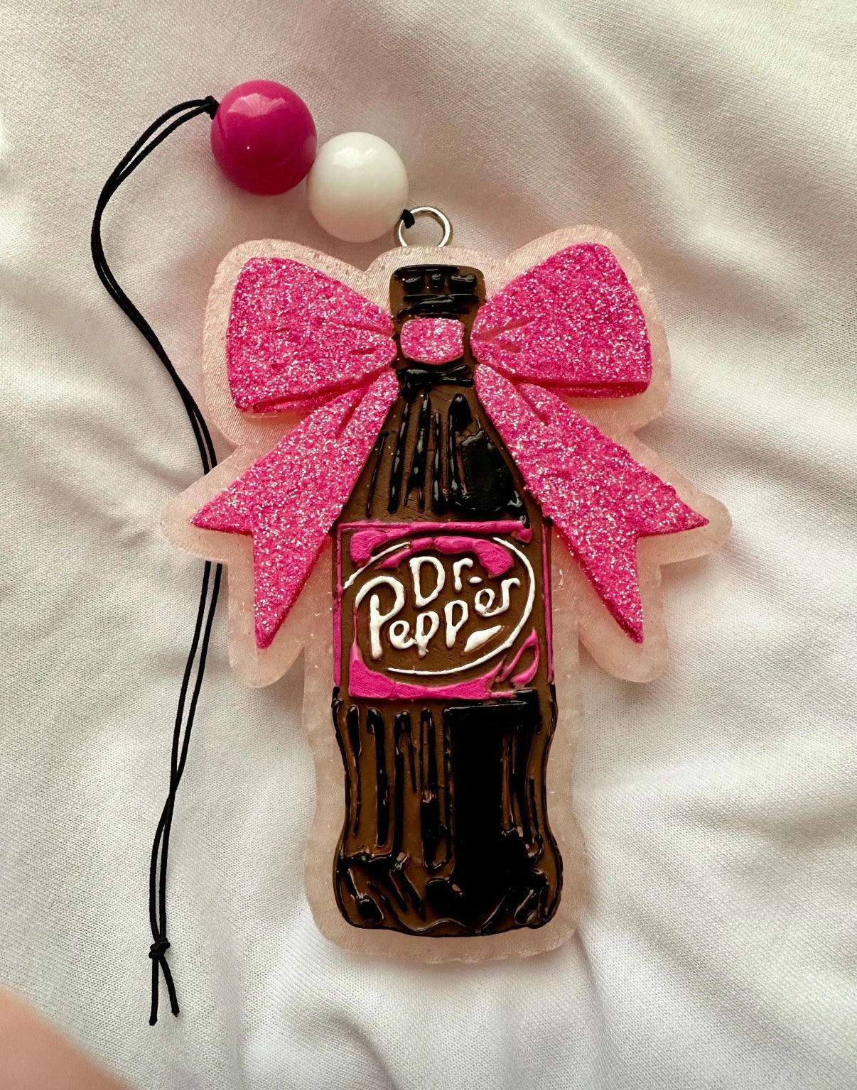 Dr Pepper bottle charm with pink bow on a white background