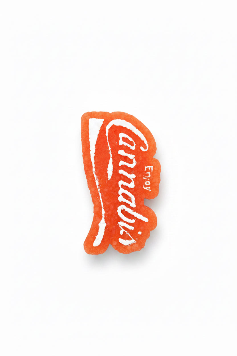Red and white 'Enjoy Cannabis' sticker on a wooden surface