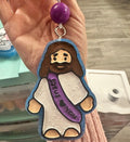 Keychain with a character wearing a purple scarf with 'I love you' text, held by a hand.