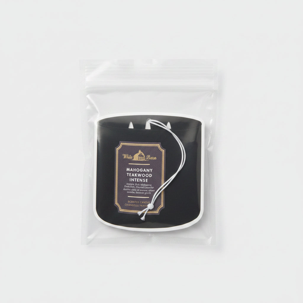 Manzanita Teakwood Intense air freshener hanging in a clear bag on a wooden surface.