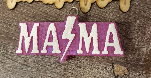 Fabric patch with 'MASMA' text and lightning bolt on a wooden background